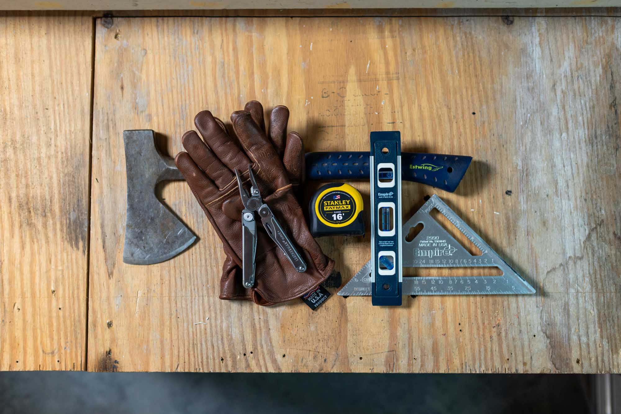 Estwing axe, Golden Stag gloves, Leatherman, Stanley tape, Empire level and square laid out together